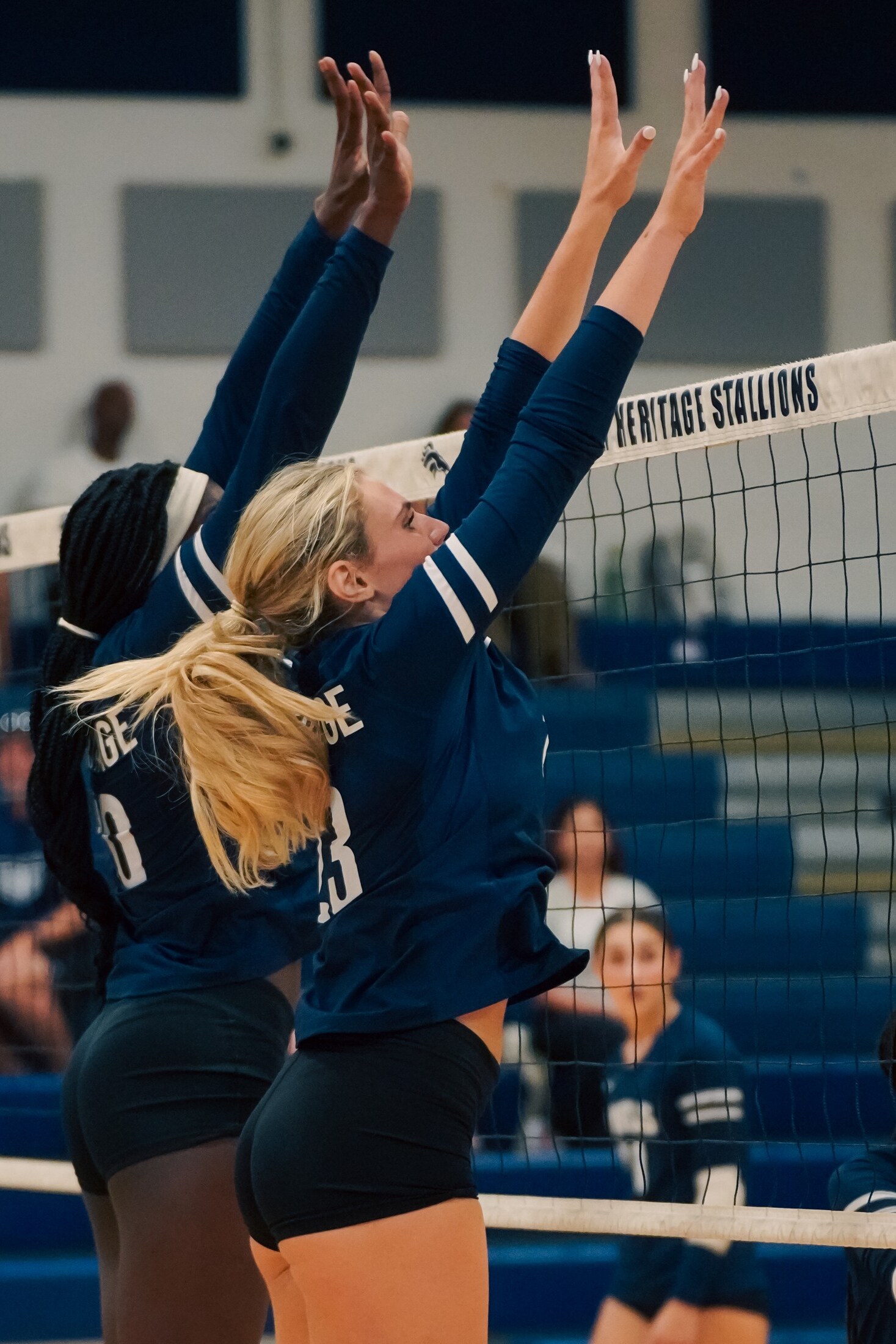 Volleyball players blocking at the net