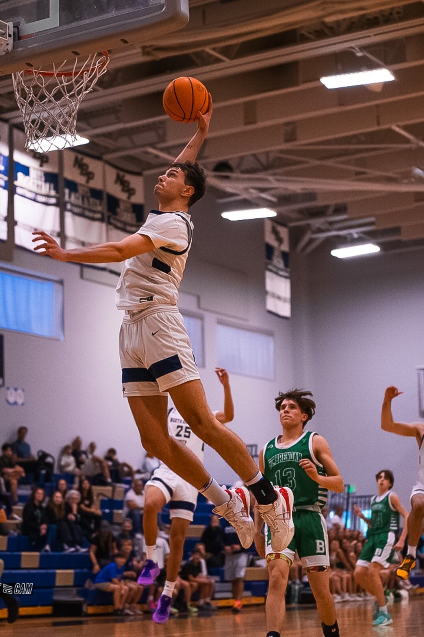 Basketball player rising to the rim in a packed gym