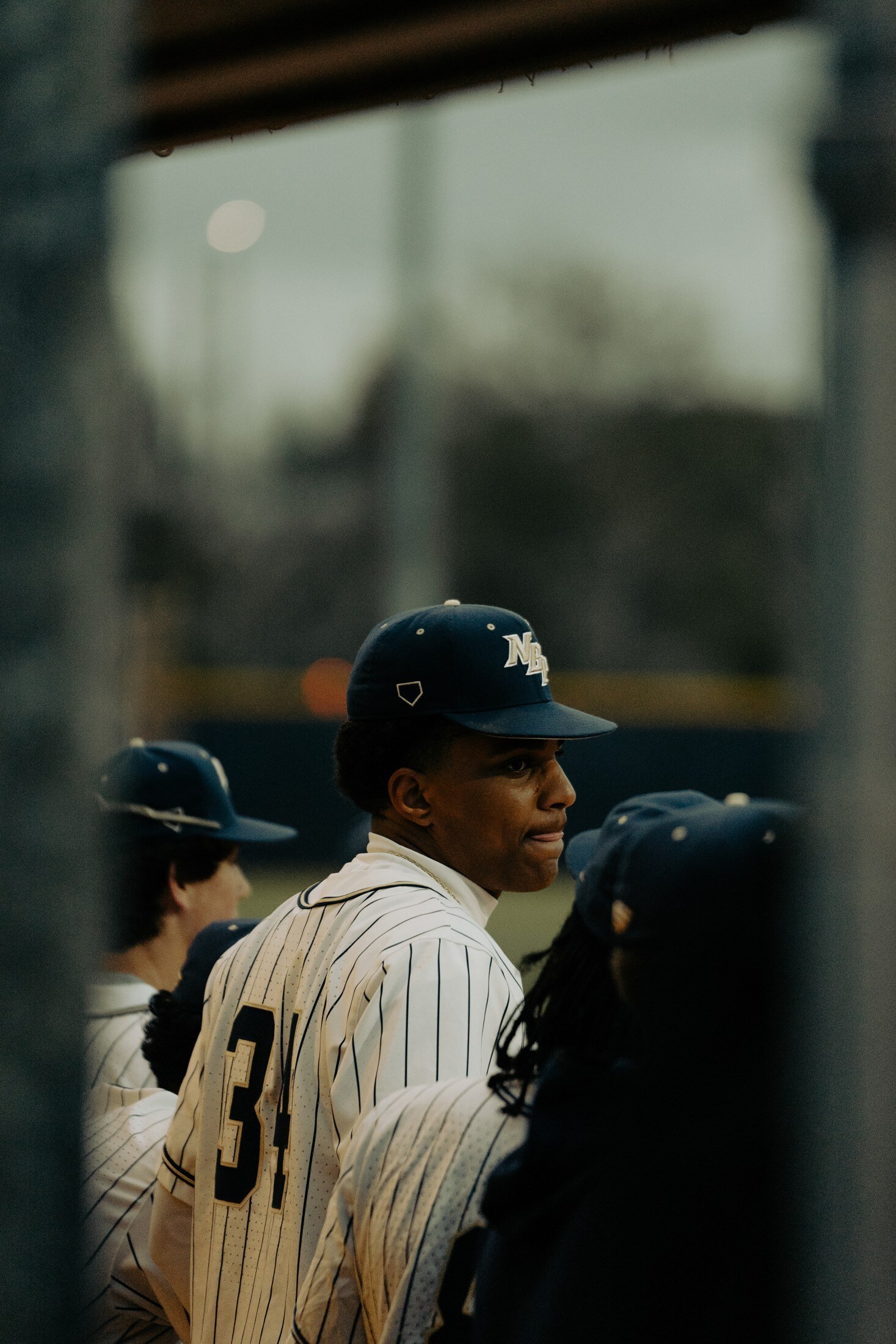 Baseball player in the dugout through the fence